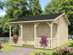 a small wooden building with flowers on the porch