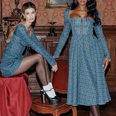 two women in dresses and high heels posing for the camera