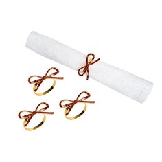 three pairs of gold rings tied together on a white napkin with red string attached to it