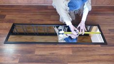 a woman is measuring the width of a window pane with a tape and scissors