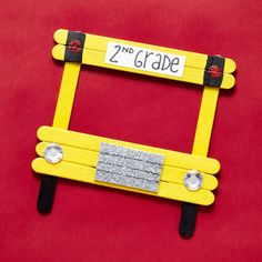 a yellow and black frame with two magnets on it that says 2 nd grade