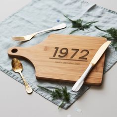 a cutting board with a knife, fork and spoon on it next to a napkin that says daddy king of the kitchen