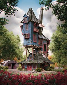 a blue house with red shutters in the middle of flowers and trees around it