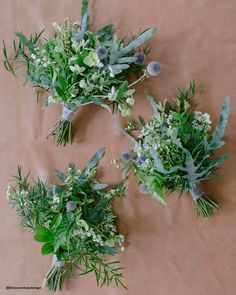 three bouquets of green and white flowers on a brown background