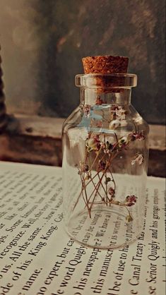 a glass jar filled with flowers sitting on top of a table