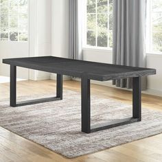 a black table sitting on top of a hard wood floor next to a white rug