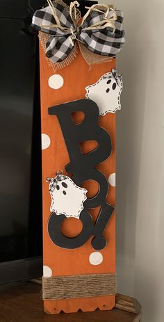 an orange and black paper bag with the letter b is for boo spelled in polka dots