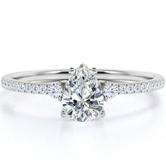 a white gold engagement ring with an oval cut diamond in the center and pave set shoulders