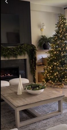 a living room with a christmas tree in the corner and a bowl on the coffee table