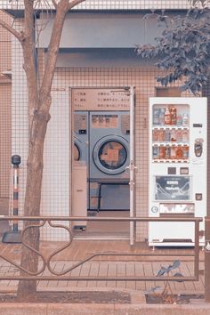 an old washing machine sitting next to a tree in front of a washer and dryer