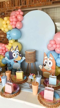 an assortment of items displayed on a table with balloons in the shape of cartoon characters