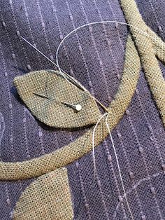 a piece of cloth with some scissors and thread on it that is attached to the fabric