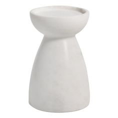 a white vase sitting on top of a table