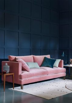 a pink couch sitting on top of a white rug