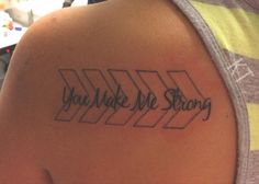 a person with a tattoo that says you make me strong