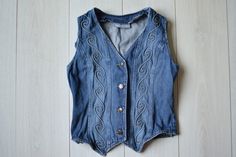 Ornamented vintage denim vest from 90s. Size : marked size (36); seems like women's (XS/S)  Measurements: Length: 53 cm/ 21" Shoulder to shoulder: 30 cm/ 12" Chest: 84 cm/ 33" Fabric: cotton Brand: KappAhl More vintage vests here: https://www.etsy.com/dk-en/shop/TumbleweedsATTiTUDE?section_id=26366388 Whole shop here: https://www.etsy.com/shop/TumbleweedsATTiTUDE KEEP IN MIND: Photo might be slightly different from actual item in terms of color due to the lighting during photo shooting or your m Y2k Style Cotton Denim Vest For Spring, Y2k Cotton Denim Vest For Spring, Casual Denim Festival Vest, Casual Denim Vest For Festivals, Fitted Bohemian Denim Vest In Medium Wash, Fitted Retro Vest For Festivals, Sleeveless Denim Vest For Festivals, Fitted Vintage Blue Denim Vest, Casual Fitted Vest For Festivals