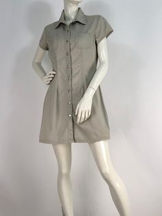 "Vintage khaki dress, button front dress, squeeze jeans size medium  Measurements:  shoulder 16\"/sleeve 5\"/bust 19\"/waist 15\"/hip 19.5\"/length 32\" mannequin measures 5ft 8\", bust 34\", waist 25\", hip 33\" Please note that vintage clothing sizes can vary greatly.  The Measurements provided  are approximate and are taken lying flat.  I suggest taking a similar garment from your wardrobe and measure it while lying flat.  This way you can compare measurements.  All of our pieces are genuine vintage. Don't forget to enlarge the photos and take a closer look at this genuine vintage item!! International destinations other than US may take 4-6 weeks or longer unless you choose to upgrade shipping for faster delivery. Please note buyer is responsible for any duties, taxes or customs clearan Casual Khaki Dresses With Pockets, Fitted Summer Shirt Dress With Pockets, Fitted Short Sleeve Shirt Dress For Fall, Casual Stretch Mini Dress With Buttons, Spring Stretch Button-up Dress, Casual Khaki Cotton Dress, Spring Button-up Stretch Dresses, Stretch Summer Dresses With Button Closure, Summer Stretch Dresses With Button Closure