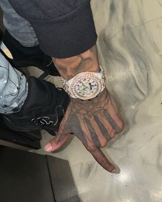 a man with tattoos on his arm and wrist is holding onto a hand that has a watch on it