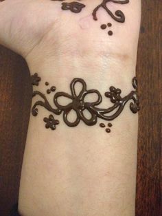 a woman's wrist with a tattoo design on it