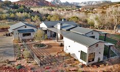 an aerial view of a house with mountains in the background