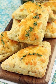 cheesy biscuits on a cutting board with a cup of tea