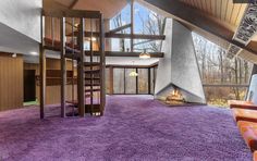 a living room with purple carpet and stairs