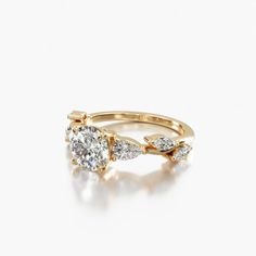 a yellow gold ring with three pear shaped diamonds