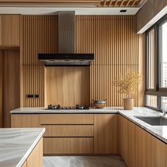 a kitchen with wood paneling and marble counter tops, along with an island in the middle