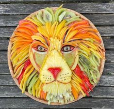 a fruit carving of a lion's face on a wooden table