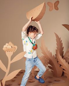 a young boy is jumping in the air with a piece of wood on his head