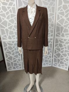 This is a quality made Max Mara warm mid brown Prince of Wales check soft fine wool suit with a 1940s vibe. The jacket has a  low open neck and medium lapels, a double breasted front with a single button to close ( plus the one inside to position the jacket nicely) patch pockets and the sleeves are wrist length with a single button. The skirt is a pencil skirt to below the knees with two inverted pleats at the front and one deep inverted back pleat. There is a back nylon zipper and both pieces a Brown Wool Suit, Suit Double Breasted, Prince Of Wales Check, Pleat Skirt, Skirt Medium, Open Neck, Soft Brown, Wool Suit, Double Breasted Blazer