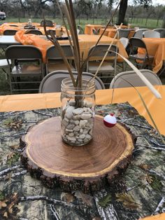 a jar filled with rocks sitting on top of a wooden table covered in orange tables cloths