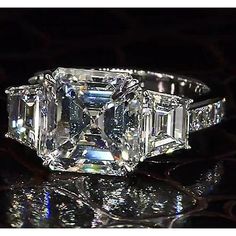 an emerald cut diamond ring sitting on top of a table