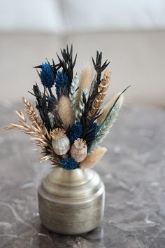 there is a vase with some flowers in it on the table and one has feathers