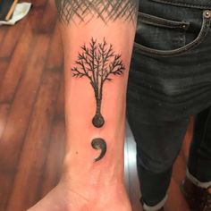 a person with a tree tattoo on their wrist