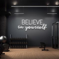 an exercise room with neon signs above the door and dumbs on the floor in front of it