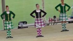 three women in green and white plaid outfits standing on stage with their hands on their hipss