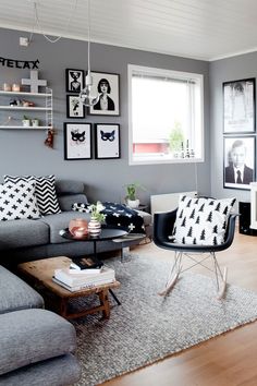 a living room with gray walls and pictures on the wall above the grey couches