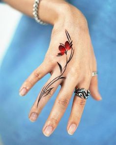 a woman's hand with a flower tattoo on it