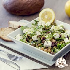 a salad with cucumber, chickpeas and feta cheese in a white bowl