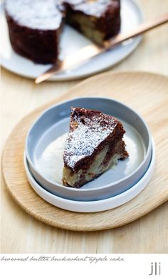 a piece of cake sitting on top of a white plate next to a wooden cutting board