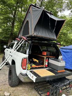 the back end of a white truck with an awning on it's bed