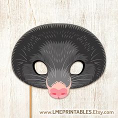 a black cat mask with pink nose on a wooden background that says, i'm terrible