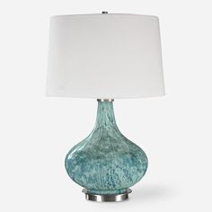 a blue lamp with a white shade on it's side and a silver base