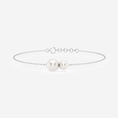 This chic double pearl floating bracelet proves that some things are better in pairs. Two lustrous pearls sit beautifully along a dainty 14K gold chain, exuding subtle elegance and curiosity with their varying sizes. Minimal and delicate, this double pearl floating bracelet is perfect for everyday wear whether worn solo or in a stack. Luxury Dainty Pearl Drop Bracelet, Cheap Classic Silver Pearl Bracelet, Minimalist Formal Bracelets With Round Beads, Delicate Pearl White Bracelet For Formal Occasions, Formal White Gold Bracelets With Pearl Chain, Minimalist Round Bead Bracelets For Formal Occasions, Formal Silver Akoya Pearl Bracelets, Elegant White Gold Pearl Bracelet For Anniversary, Elegant Akoya Pearl Bracelet With Pearl Chain