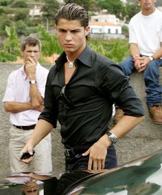 the young man is standing next to his car