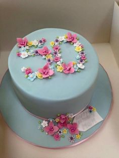 a blue cake decorated with flowers and the number 50