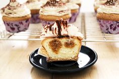 cupcakes with frosting and cinnamon on top are sitting on a black plate