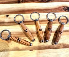 five wooden keychains sitting on top of a wooden table