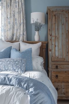 a bedroom with blue walls and white bedding